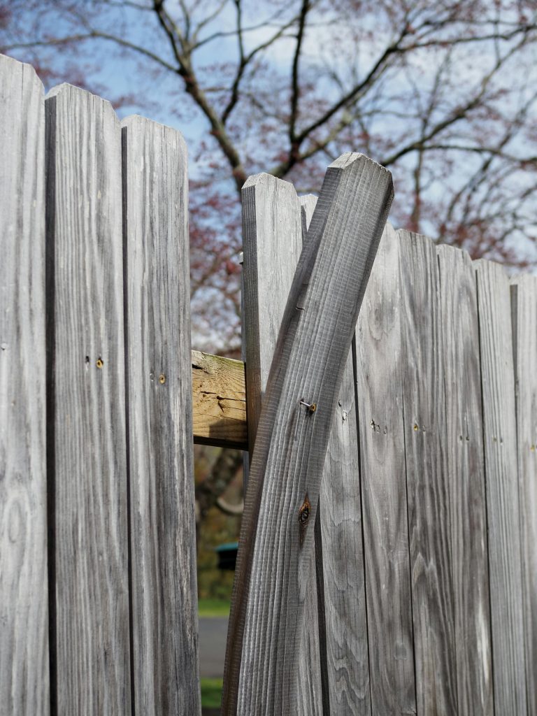 Close-up view of a weathered wooden fence against a clear sky in New Britain.
